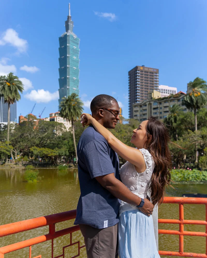 Couple at Tsuei Heng Pagoda with Taipei 101 in the background in Taiwan.