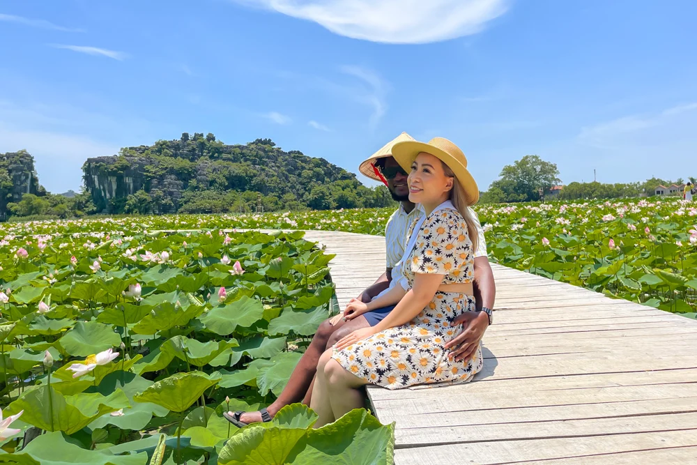 Couple at lotus pond in Ninh Binh, Vietnam.